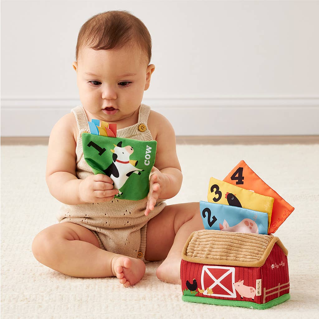 Baby playing with colorful educational toys on a light-colored floor.