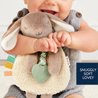 Child holding a soft toy with text 'Snuggly Soft Lovey' on a light background