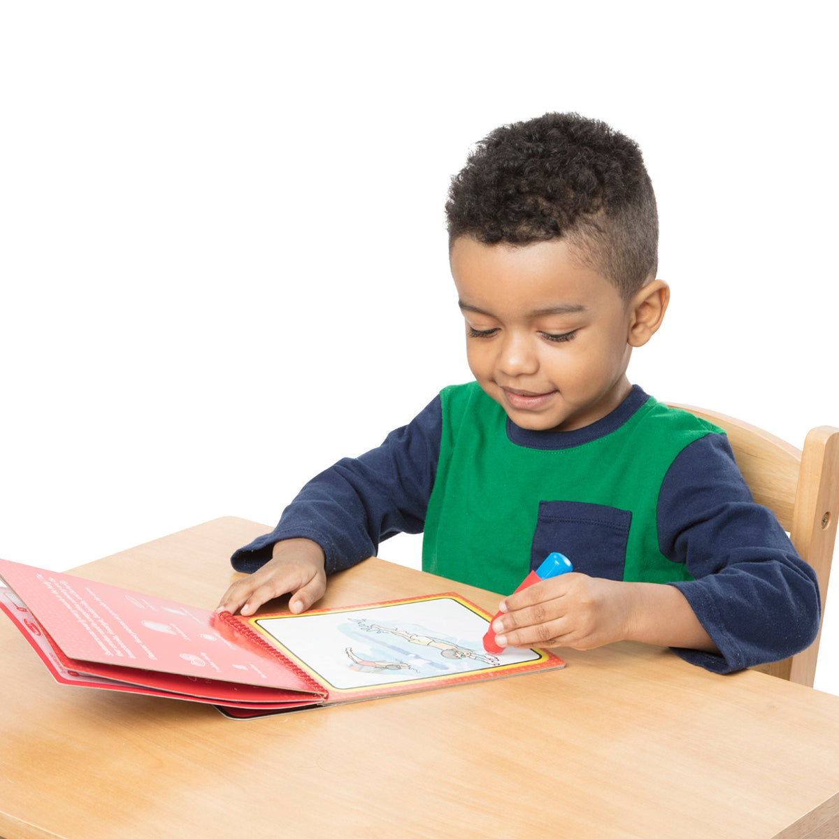 Young boy coloring with a red marker on a white background