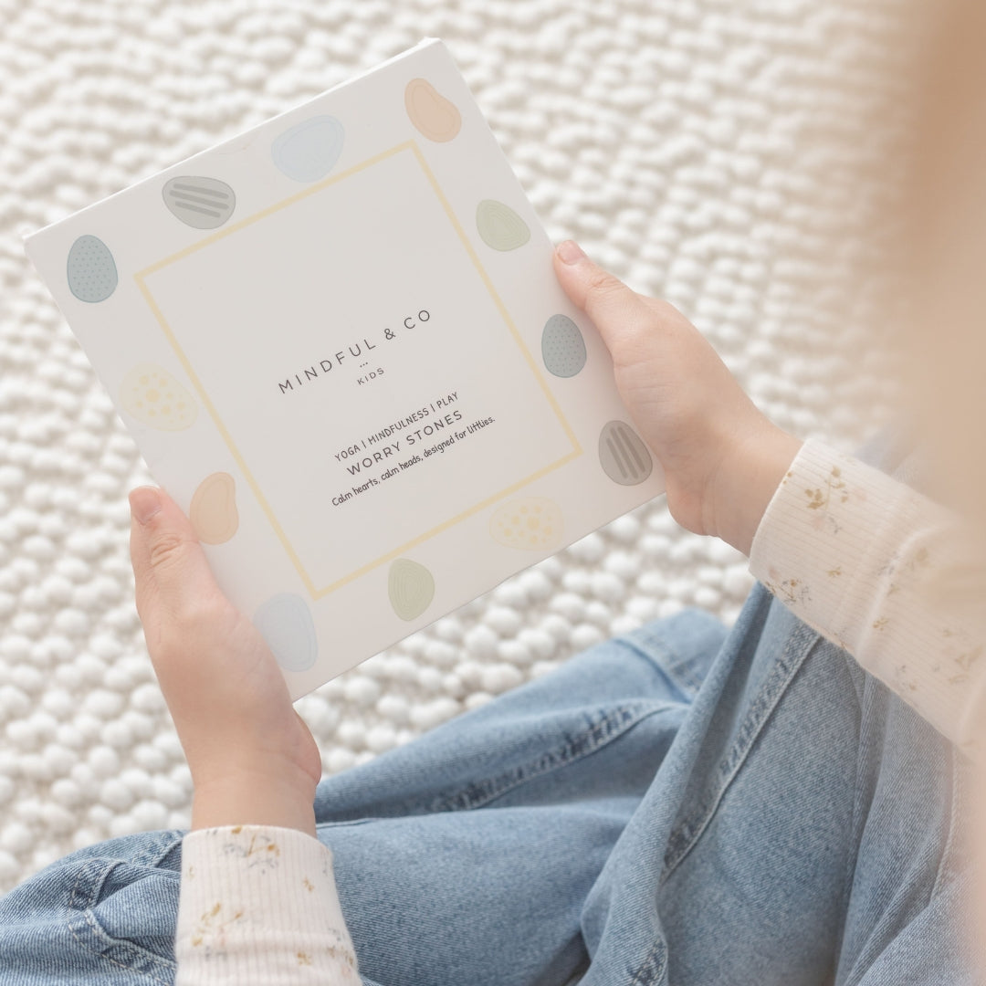 Person holding a product with 'Mindful & Co' branding on a textured surface