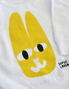 White shirt with a yellow cartoon bunny face and 'SUPER LOVED' text on a white background