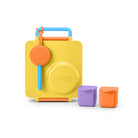 A yellow OMIE lunch box with a blue handle and orange latch, shown on a white background with two small accessory containers in purple and orange.