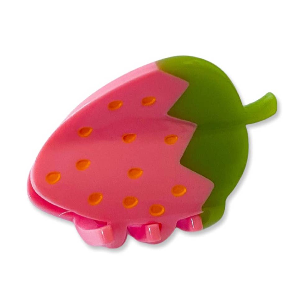 A strawberry-shaped pink and green plastic hair clip, shown on a plain white background.