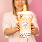 Person holding a bubble tea with a pink background