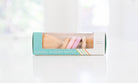 Box of a classic wooden rattle with colorful handles on a white background