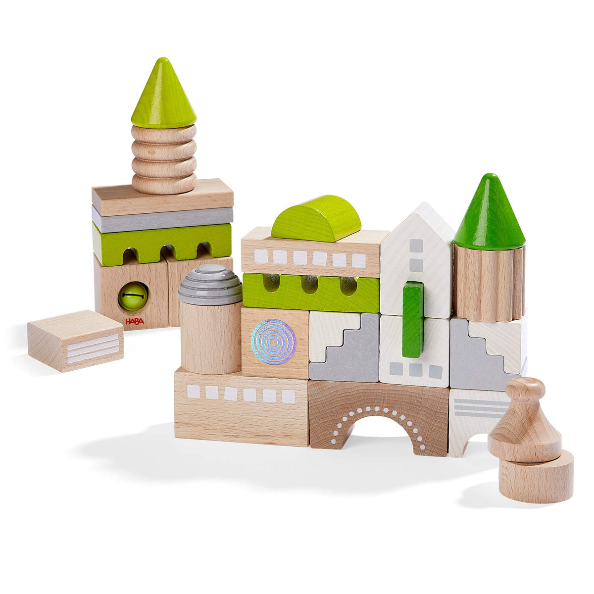 Wooden toy blocks shaped like a castle with green roofs on a white background