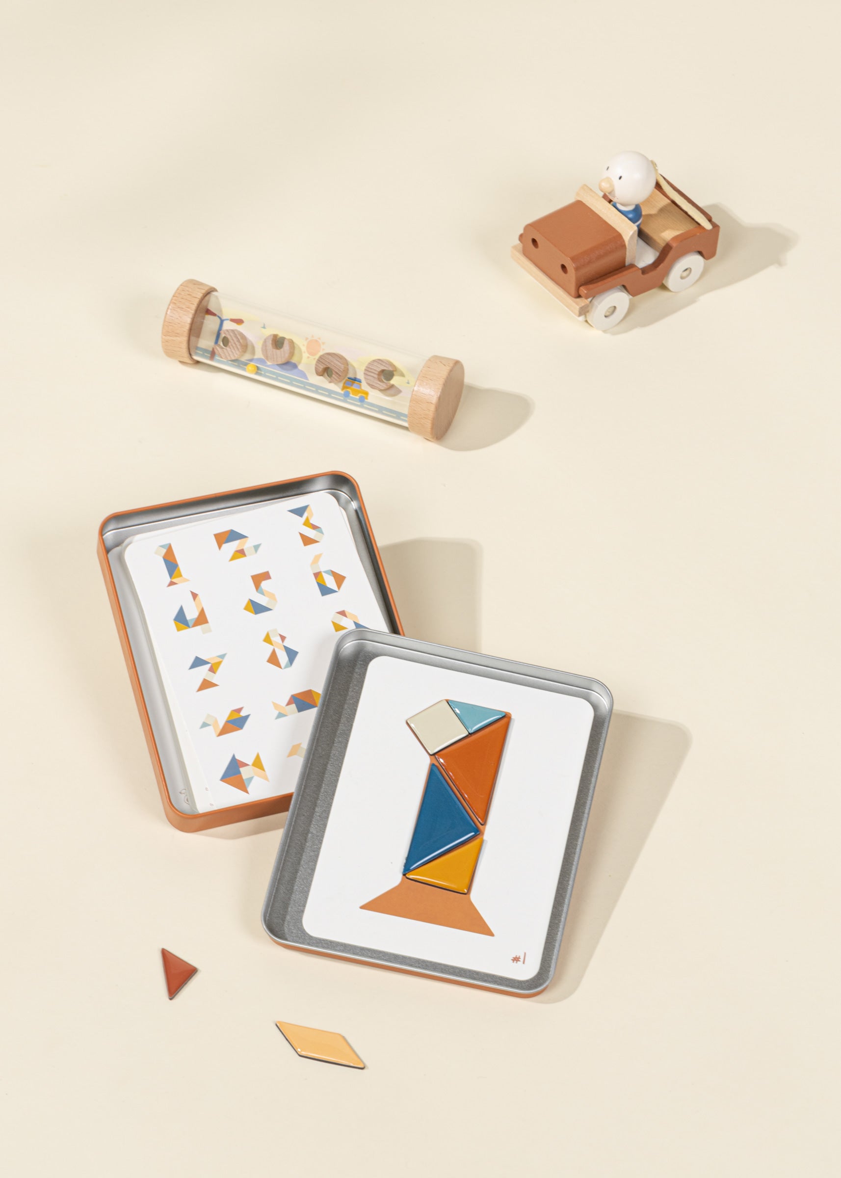 Set of geometric wooden puzzle pieces in a tin on a beige background