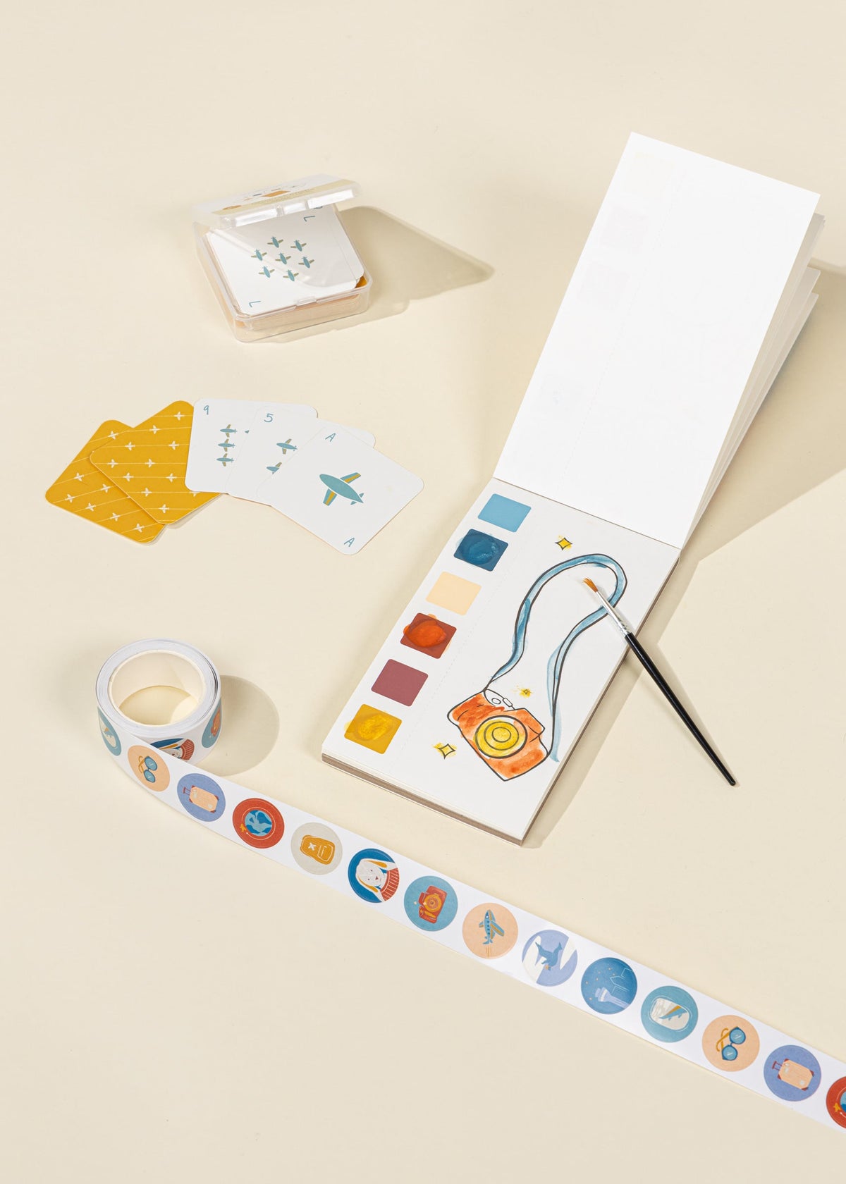 Color swatches, stickers, and a paintbrush on a beige surface