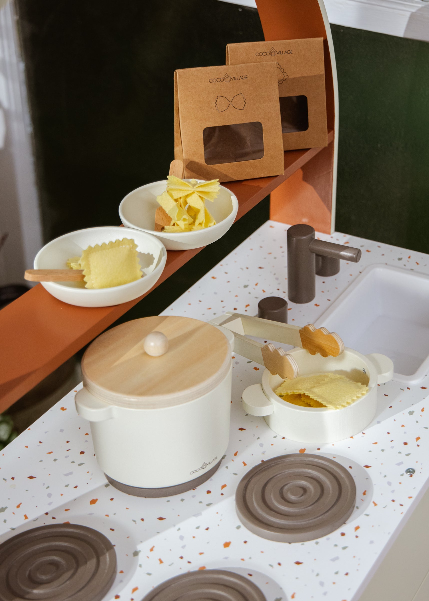 Kitchen setup with a pot, bowls, and kitchen tools on a speckled countertop.