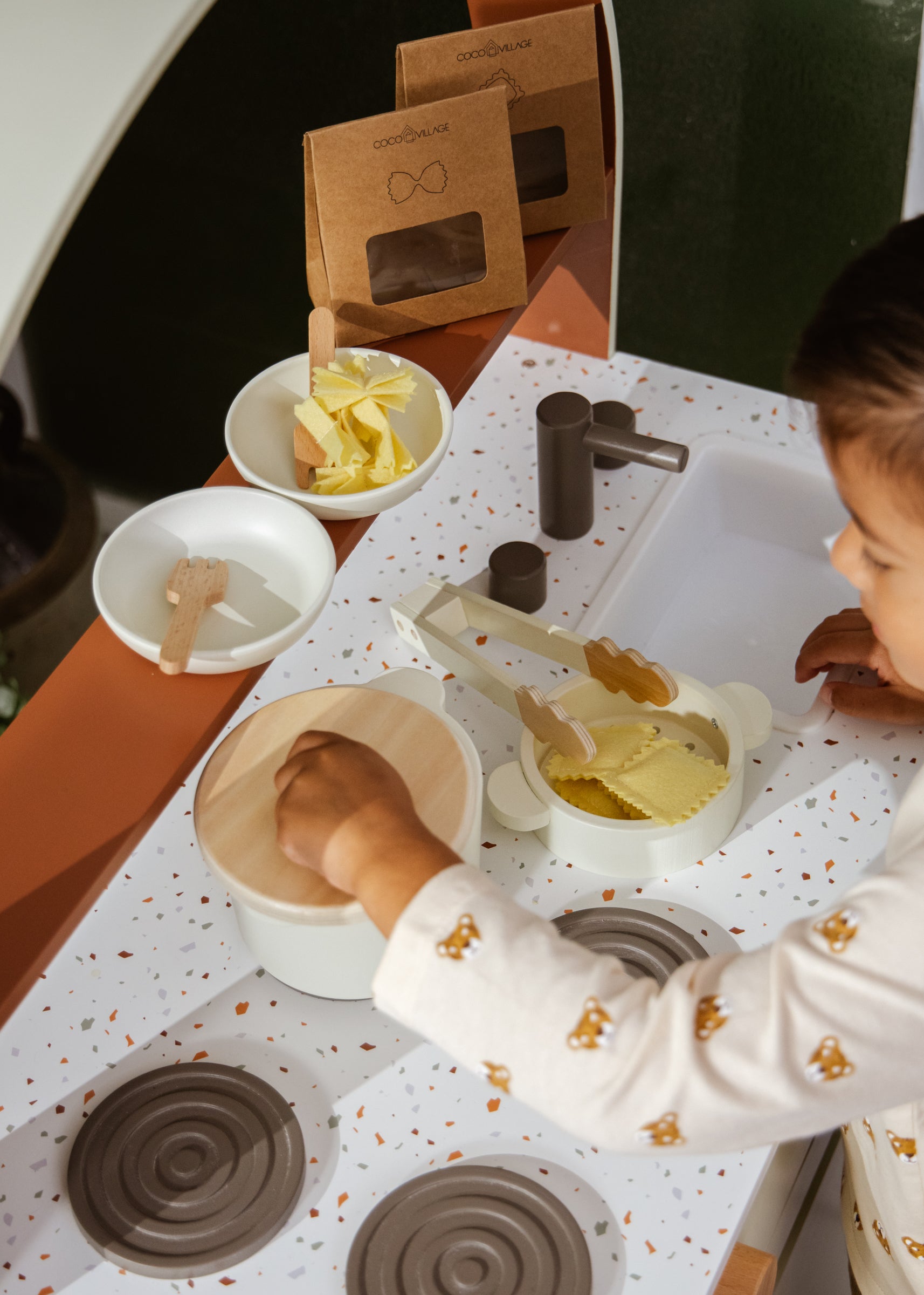 Child playing with play dough on a kitchen counter