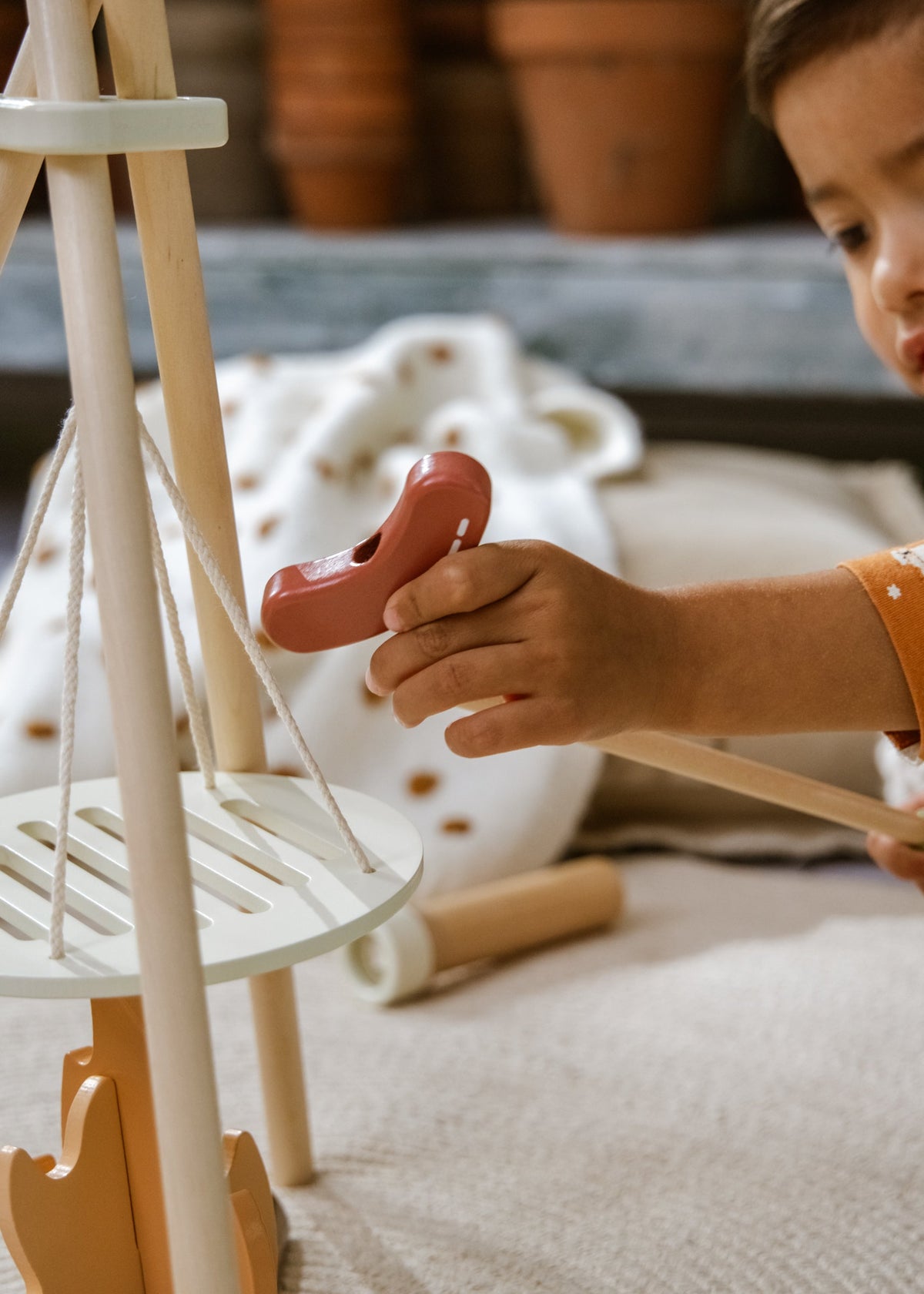 Child playing with a toy shoe in a cozy indoor setting