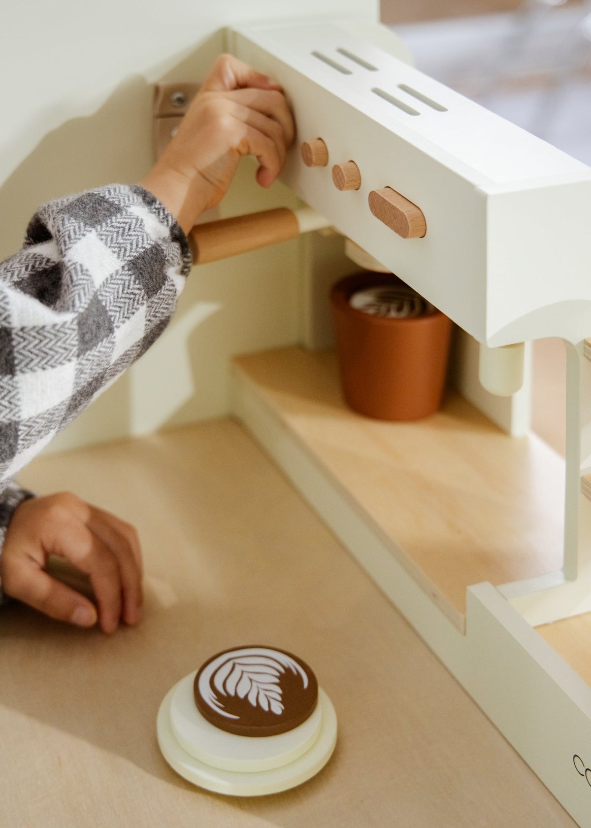 Person using a cookie press to create cookies on a wooden surface.