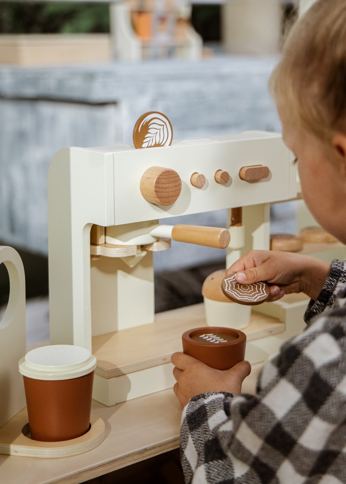 Child playing with a wooden coffee grinder set
