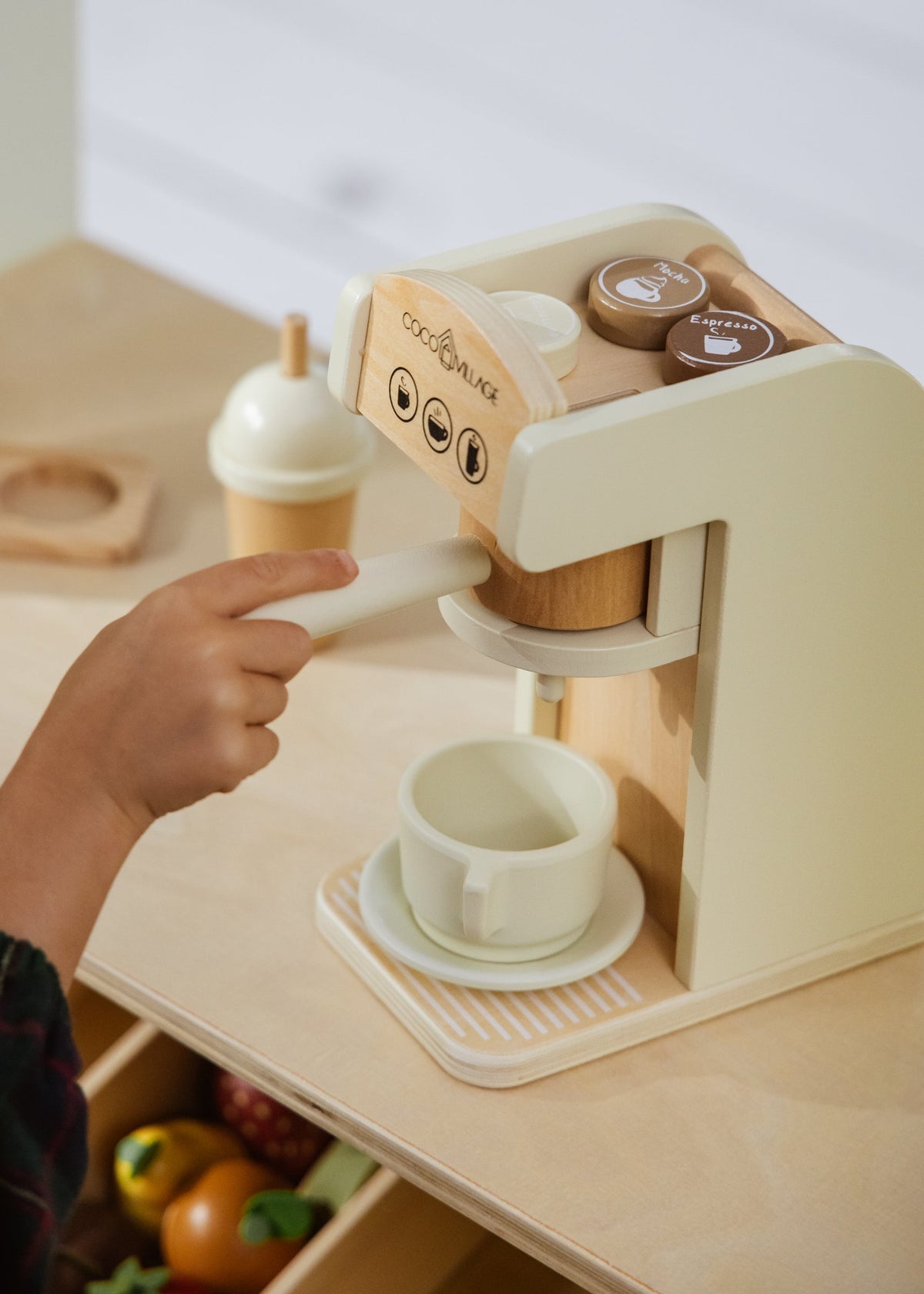 Children's play kitchen set with a wooden espresso machine and toy ingredients.