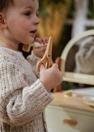 Child holding a wooden tool with a blurred background