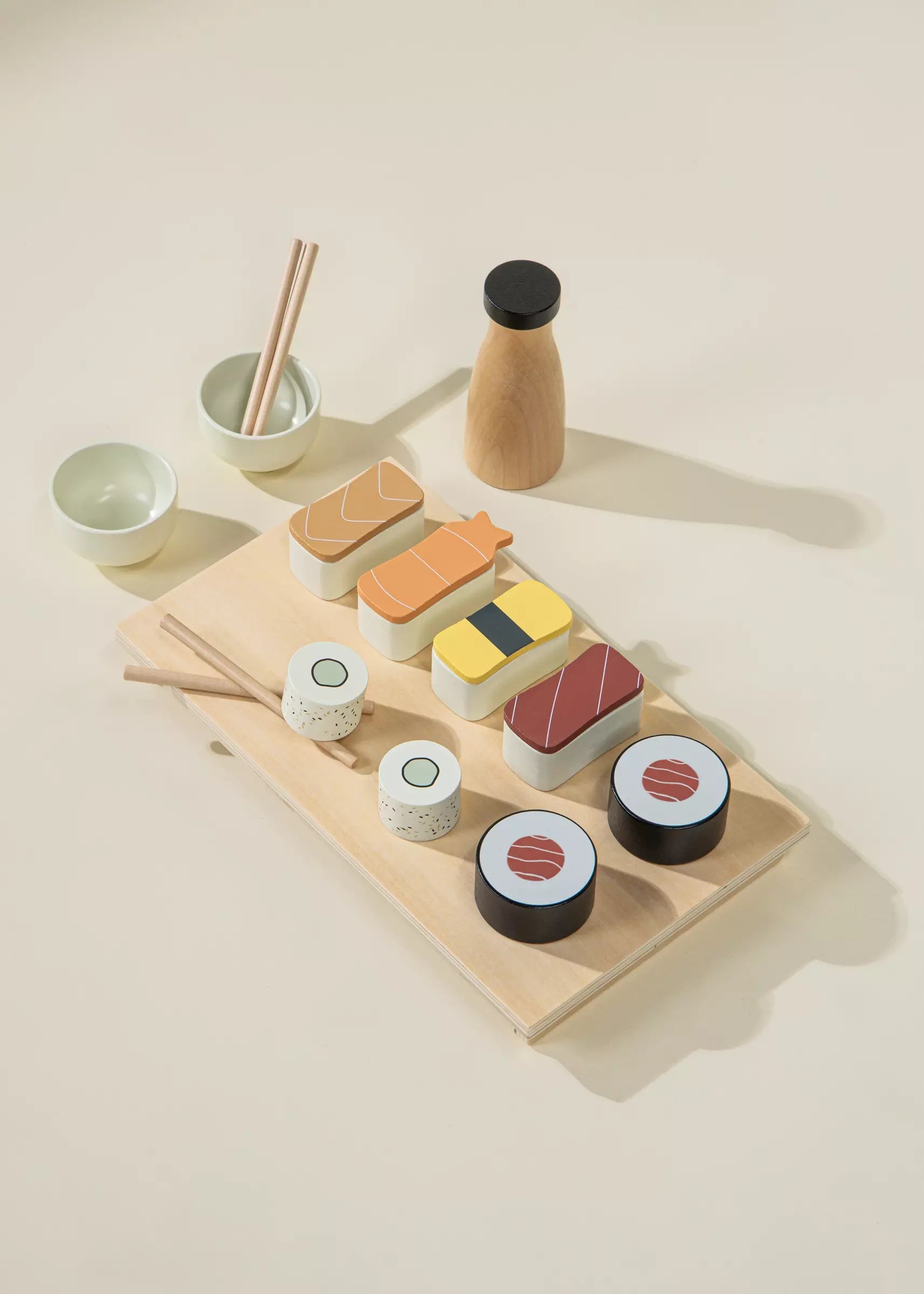Wooden toy set resembling sushi on a beige surface with a neutral background