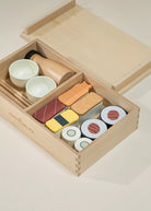 Wooden toy set resembling sushi in a box on a light background