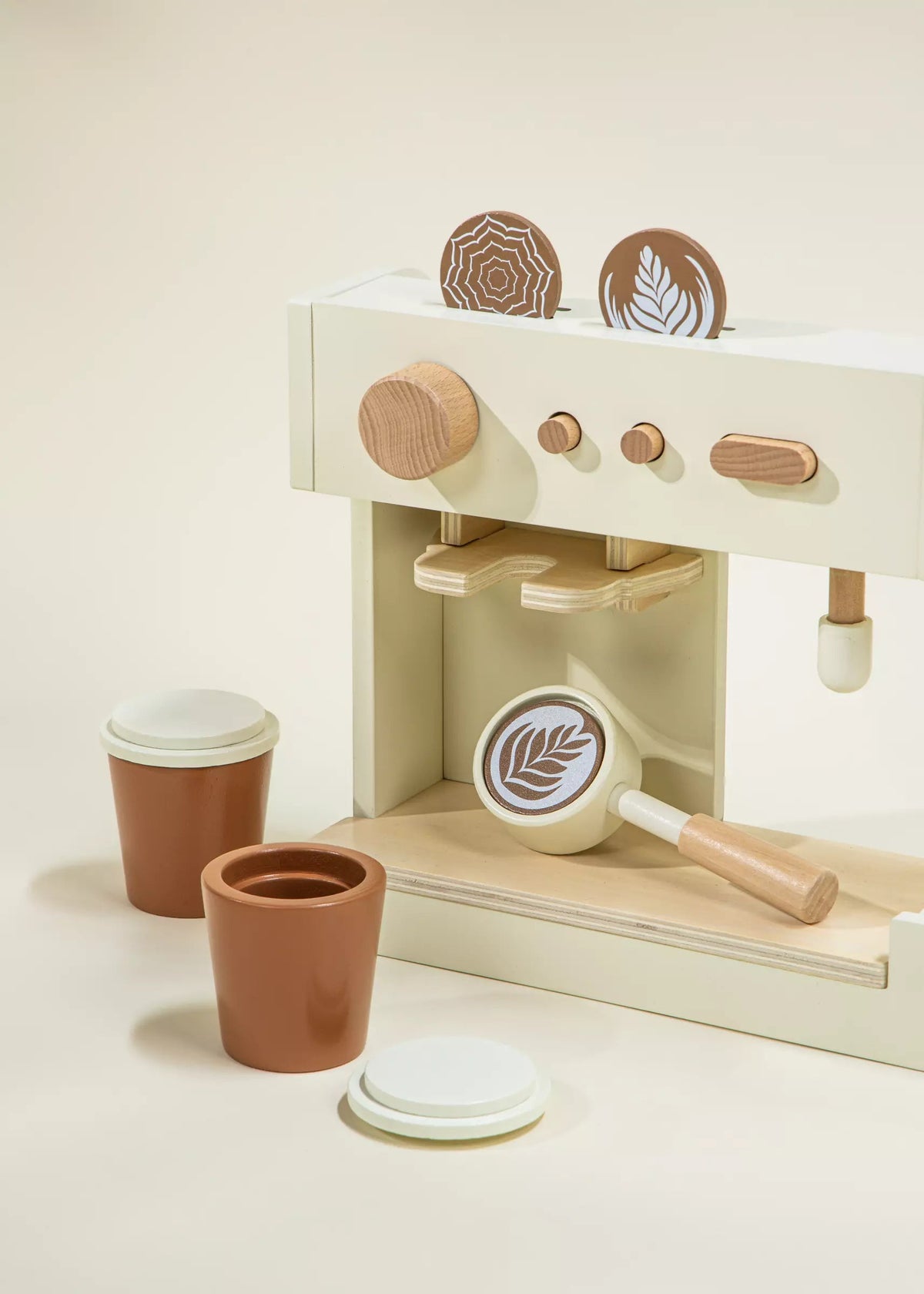 Wooden toy coffee set with a coffee machine, cups, and other accessories on a light background
