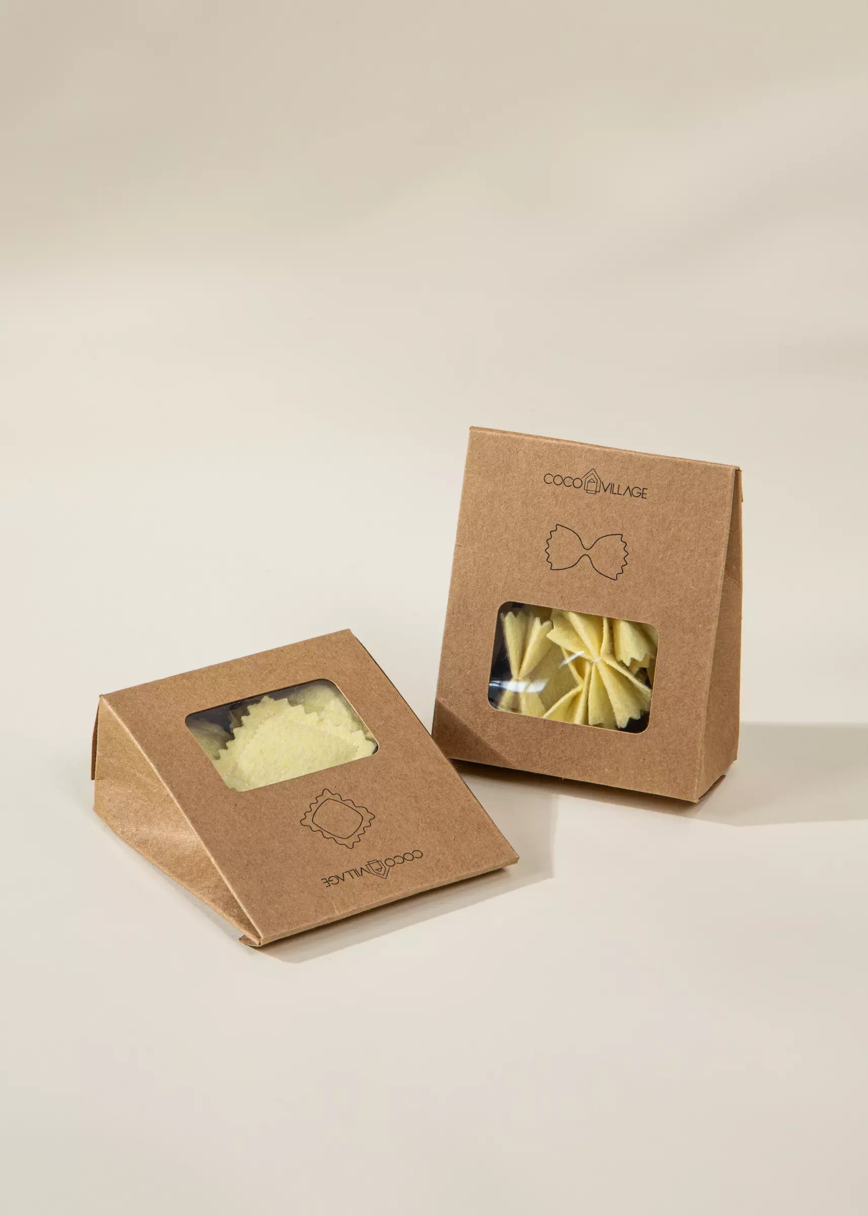 Two cardboard boxes with windowed fronts on a beige background