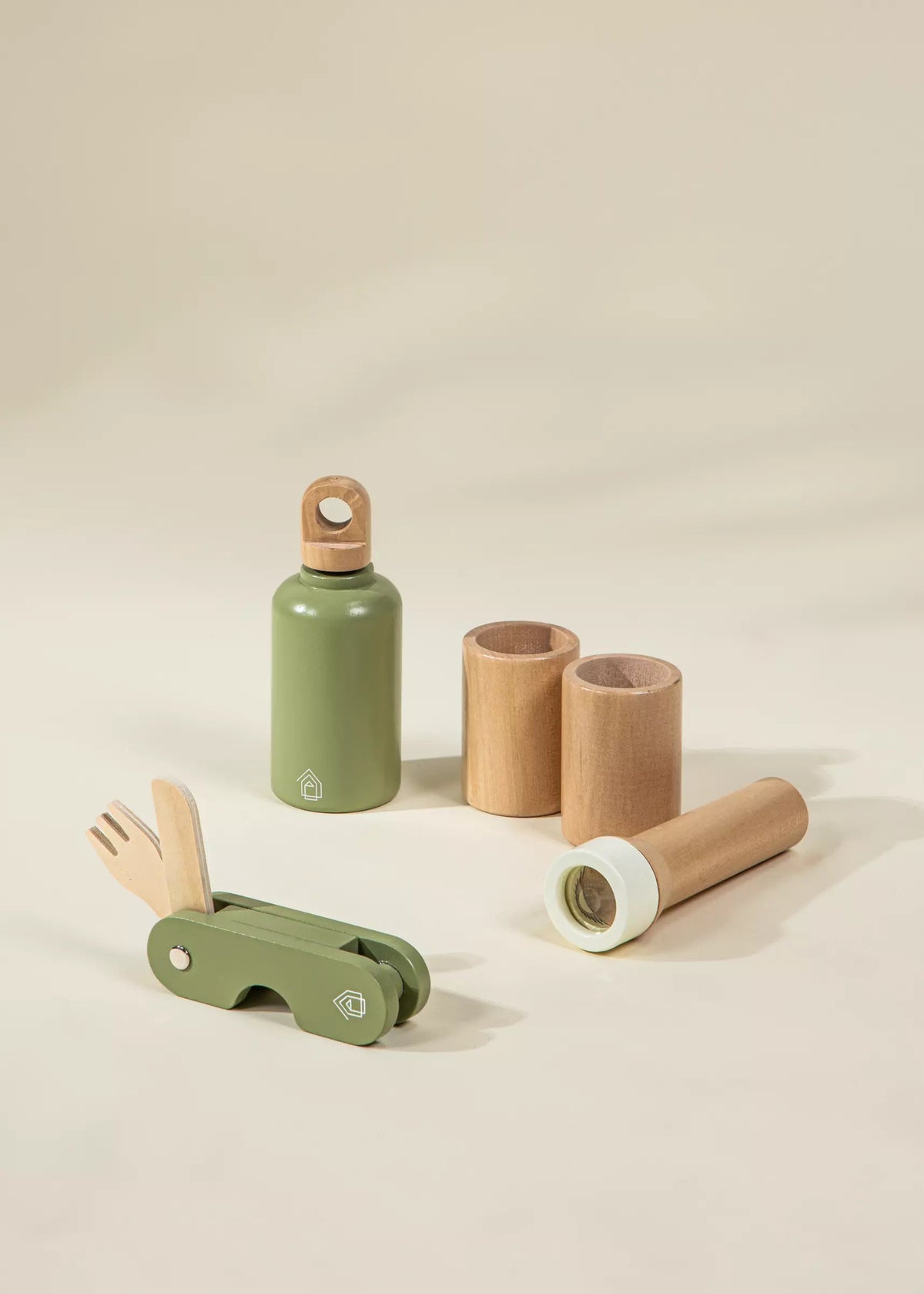Set of green and brown children's toys on a beige background