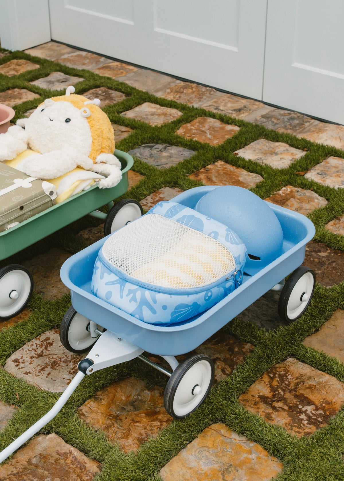 Blue pet stroller with a cushion on a stone patio