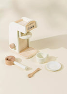 Wooden toy kitchen set with a coffee maker on a beige background