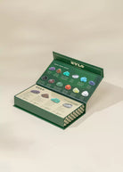 Open green box with gemstones and a ZYLO label on a beige background