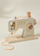 Toy sewing machine with wooden components on a light background