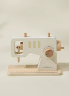 Wooden toy sewing machine with a beige background