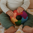 Child holding a colorful puzzle toy on a patterned surface