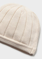 Beige knitted beanie on a light gray background