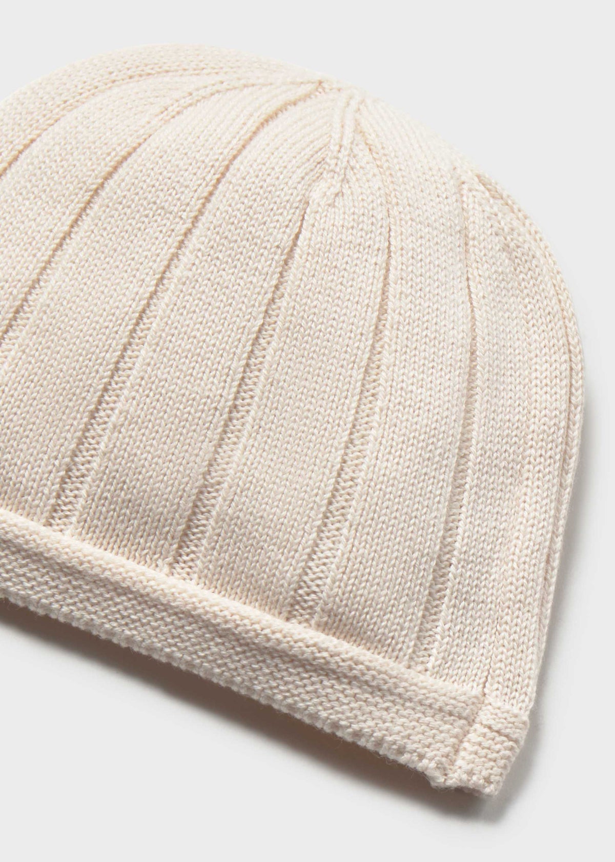 Beige knitted beanie on a light gray background