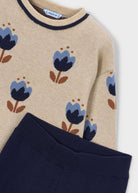 Beige sweater with blue floral patterns on a white background