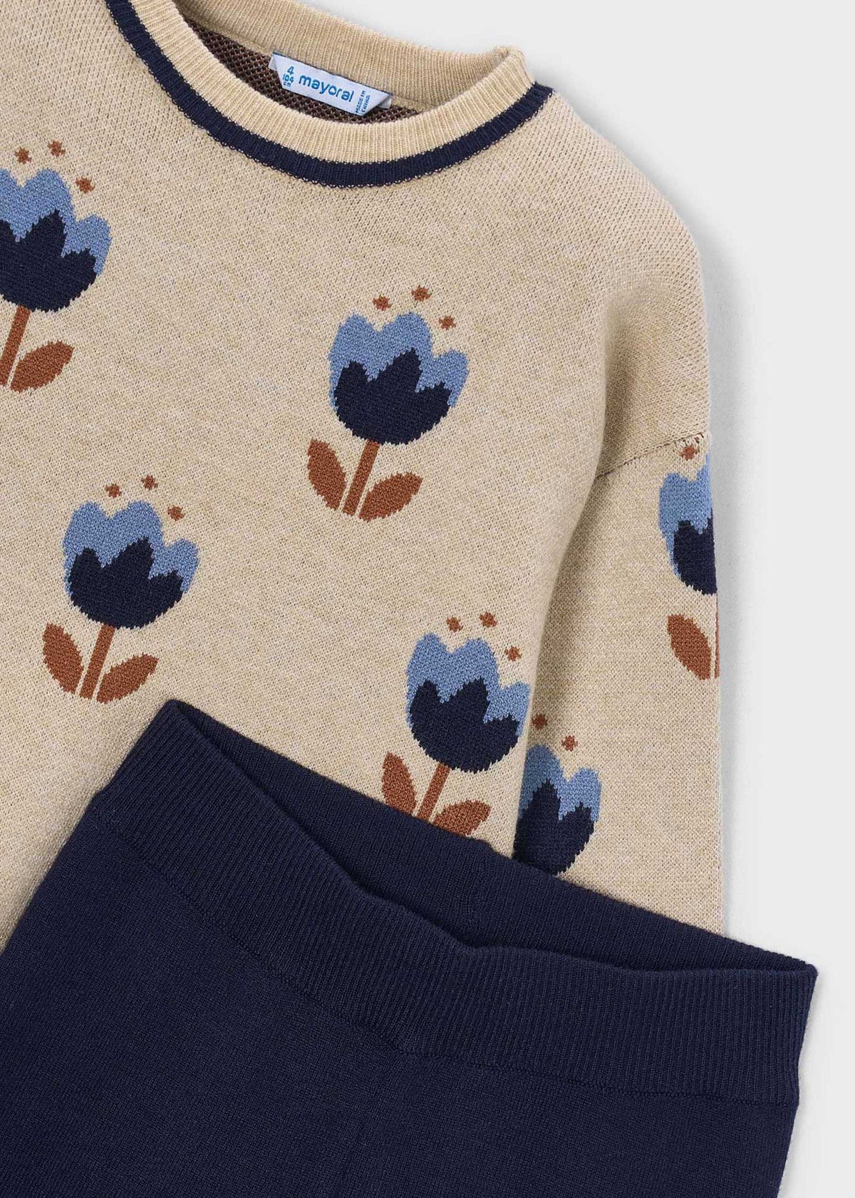 Beige sweater with blue floral patterns on a white background