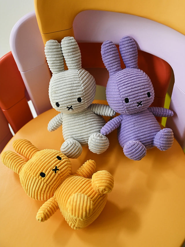 Three colorful plush toys on a yellow chair