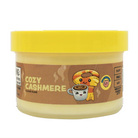 A jar of Cozy Cashmere Cloud Slime party makeup by NECA, featuring a bright yellow lid and a brown label with a cartoon character holding a coffee cup.