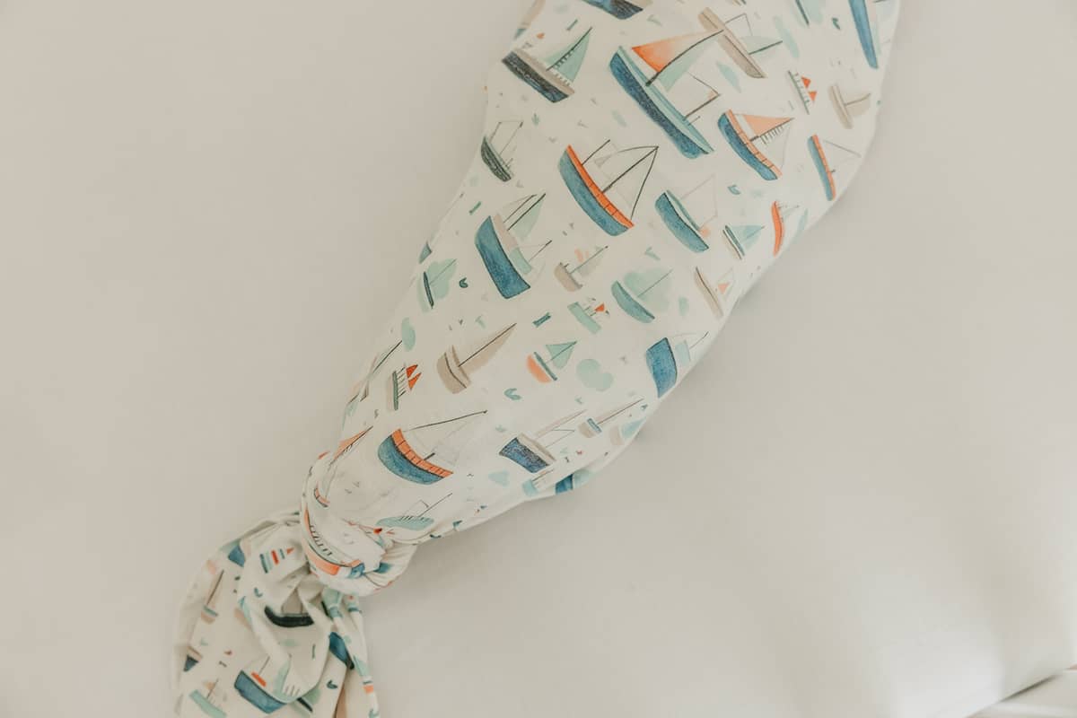 Baby swaddle with boat pattern on a light background