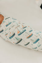 Baby swaddle with sailboat pattern on a white surface