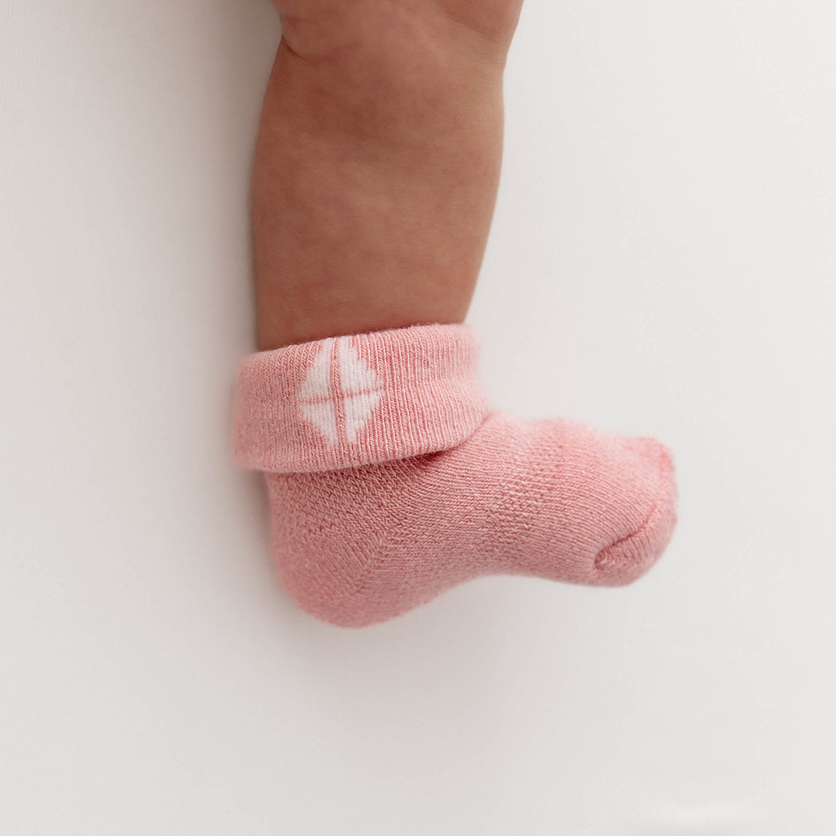 Pink baby sock on a white background
