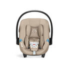 Beige baby car seat with black frame on a white background