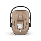 Beige baby car seat with black frame on a white background