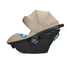 Baby car seat with beige canopy and black base on a white background