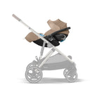 Baby stroller with beige canopy and black seat on a white background