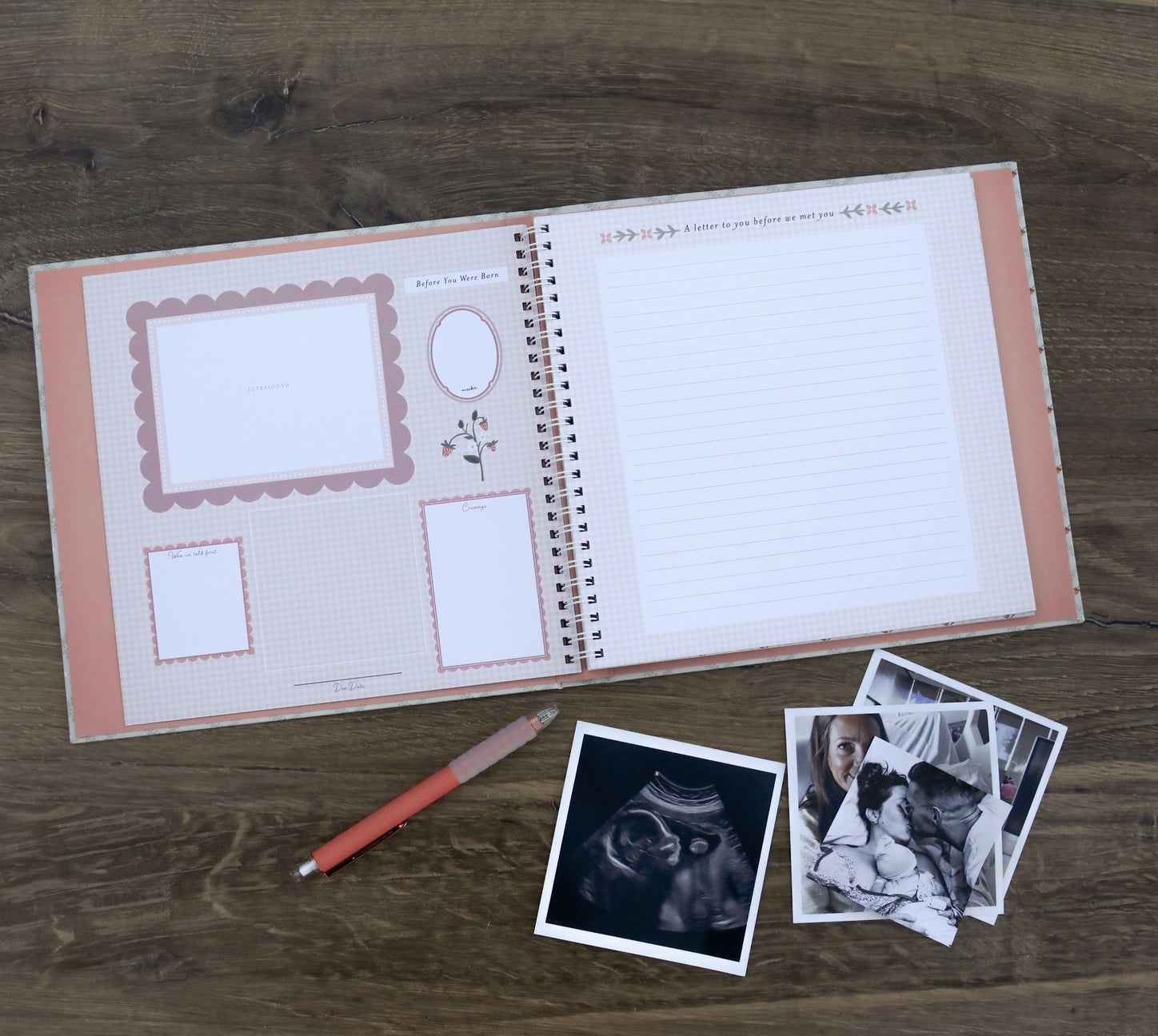 Open notebook with pre-printed pages on a wooden surface with photos and a pen.