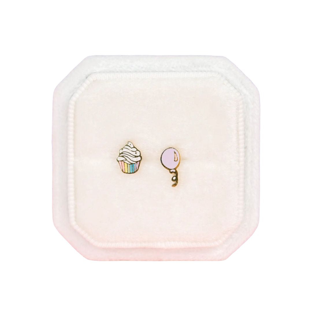 Two earrings in a pink jewelry box on a white background