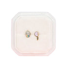 Two earrings in a pink jewelry box on a white background