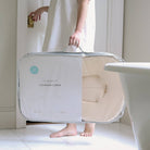 Person holding a 'snugglemee Lounger Curve' product in a bathroom setting