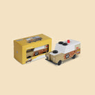 Toy truck with giraffe pattern and packaging on a beige background