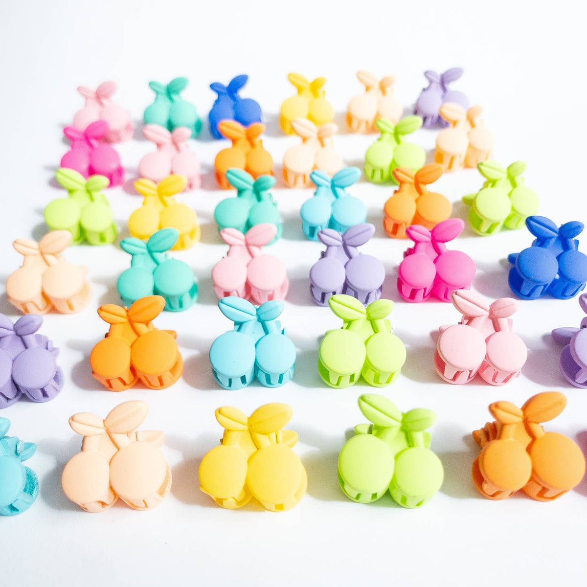 Colorful bunny-shaped clips arranged in a grid on a white background