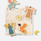 A wooden puzzle featuring four distinct angel figures and celestial elements, with phrases like "TO LIGHT", "AND GUARD", "TO RULE", and "AND GUIDE" printed around the board against a beige background.